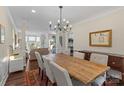 Elegant dining room with a long wooden table, chandelier, and natural light at 5854 Crimson Oak Ct, Harrisburg, NC 28075