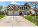 Charming two-story brick home featuring a two-car garage and a beautifully landscaped front yard at 5854 Crimson Oak Ct, Harrisburg, NC 28075