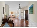 Welcoming foyer with hardwood floors, chandelier, and entry to living spaces at 5854 Crimson Oak Ct, Harrisburg, NC 28075