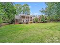 Classic brick home with white columns, shutters, and a well-maintained lawn surrounded by trees at 6730 Gold Wagon Ln, Mint Hill, NC 28227
