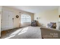 Bright living room featuring neutral walls, carpet, and large windows at 7000 David Ave, Charlotte, NC 28214