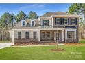 Beautiful two-story home with brick and siding, a manicured lawn, and classic architectural details at 7005 New Town Rd, Waxhaw, NC 28173