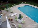 Aerial view of a sparkling in-ground pool with surrounding patio, lounge chairs and outdoor seating at 101 Saddletree Rd, Lincolnton, NC 28092