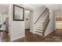 Bright entryway featuring wood floors, staircase, and access to kitchen and front door at 1027 Williamston Dr, Marshville, NC 28103