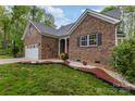 Charming brick home with manicured landscaping including mulch and flowers at 1027 Williamston Dr, Marshville, NC 28103