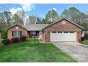 Charming brick home features a two-car garage, manicured lawn, and mature trees at 1353 33Rd Avenue Ne Dr, Hickory, NC 28601