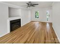 Open living room featuring a fireplace, hardwood floors, and a window view at 15188 Eric Kyle Dr, Huntersville, NC 28078