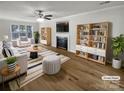 Bright living room with fireplace, built-in bookshelves, wood floors, and striped furniture at 15188 Eric Kyle Dr, Huntersville, NC 28078