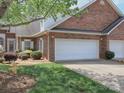 Well-manicured lawn complements the exterior of this brick home featuring a two-car garage at 1520 Royalty Cir, Statesville, NC 28625