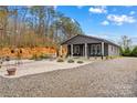 Inviting home with a covered front porch, gravel landscaping, and a peaceful setting under a blue sky at 1595 Cheatham Ford Rd, Hiddenite, NC 28636