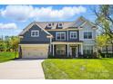 Charming two-story home with a manicured lawn, a two-car garage, and beautiful blue and grey siding at 20422 Creek Bend Edge Ct, Matthews, NC 28105
