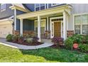 Inviting front porch with stone accents and well-maintained landscaping leading to a front door at 20422 Creek Bend Edge Ct, Matthews, NC 28105