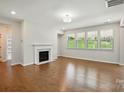 Bright living room featuring hardwood floors, a cozy fireplace, recessed lights and large windows at 20422 Creek Bend Edge Ct, Matthews, NC 28105