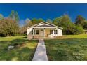 Inviting home features a covered front porch with seating, a walkway, and a well-manicured lawn at 212 W Doc Garris Rd, Lancaster, SC 29720