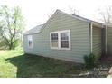 Cottage-style house exterior featuring siding and windows, set in a grassy yard with mature trees at 2547 Gastonia Hwy, Lincolnton, NC 28092