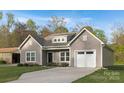 Grey single-Gathering home with a one-car garage, landscaped yard, and a well-lit driveway at 3708 Small Ave, Charlotte, NC 28269