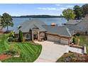 Stately brick home with a circular driveway, three-car garage, and beautiful landscaping, showcasing curb appeal at 3988 Channel Point Ln, Denver, NC 28037