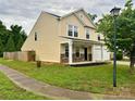 Side view of a two-story home showcasing the landscaped yard and a charming front porch with stone accents at 4418 Palustris Ct, Charlotte, NC 28269