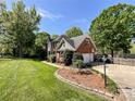 Charming brick home with an attached garage, long driveway, and a beautifully landscaped yard with mature trees at 4823 Antioch Church Rd, Weddington, NC 28104