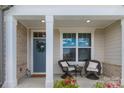 Inviting front porch featuring two wicker chairs with white cushions, perfect for relaxing and enjoying the outdoors at 5119 Moselle Ave, Fort Mill, SC 29707