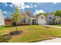 Charming single-Gathering home featuring a manicured lawn, complemented by blue sky and puffy white clouds at 5119 Moselle Ave, Fort Mill, SC 29707