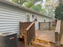 Wooden back deck with railing and steps down to the backyard and light gray siding at 5319 Springdale Ave, Mint Hill, NC 28227