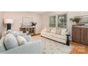 Bright living room with hardwood floors, neutral furniture, and large windows providing natural light and a cozy atmosphere at 5329 Glenbrier Dr, Charlotte, NC 28212