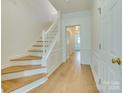 Bright foyer with hardwood floors, white trim and stairs leading to upper level at 5430 Dockery Dr, Charlotte, NC 28209