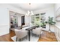 Bright dining room features hardwood floors, modern lighting, and large windows at 6036 Foggy Glen Pl, Weddington, NC 28104