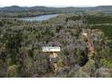 Aerial view showcasing the property's location near a lake surrounded by lush greenery at 676 Chapel Hill Dr, Troy, NC at 676 Chapel Hill Dr, Troy, NC 27371