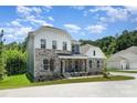 Beautiful two-story home features stone accents, a welcoming front porch, and lush landscaping at 7001 New Town Rd, Waxhaw, NC 28173