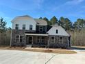 Charming two-story home with a covered porch, stone accents, dark siding, white trim, and ample parking space at 7001 New Town Rd, Waxhaw, NC 28173