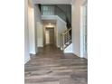 Inviting foyer featuring wood floors, a staircase with iron spindles, and an open hallway at 7001 New Town Rd, Waxhaw, NC 28173