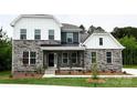 Charming two-story home featuring a covered front porch, stone accents, and a well-maintained lawn at 7001 New Town Rd, Waxhaw, NC 28173