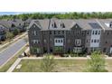 Aerial view of a brick townhome community showcasing well-maintained lawns and mature trees at 7957 Reunion Row Dr, Charlotte, NC 28277