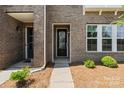 Inviting front entrance with brick facade, well-maintained landscaping, and a charming glass door at 7957 Reunion Row Dr, Charlotte, NC 28277