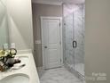 Modern bathroom with tiled shower, glass door, and double sink vanity at 1030 Mapletree Ln, Indian Trail, NC 28079