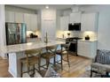 Modern kitchen featuring white cabinets, stainless steel appliances, and an island with seating at 1030 Mapletree Ln, Indian Trail, NC 28079