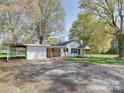 Exterior view of a white home and detached garage showing the expansive yard at 1209 Mount Ulla Hwy, Mooresville, NC 28115