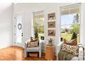 Bright sitting area featuring two armchairs, hardwood flooring, and natural light from picture windows at 211 Killian Rd, Stanley, NC 28164