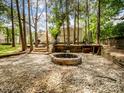 Tranquil backyard featuring a stone fire pit and mature trees, perfect for cozy gatherings at 2248 Lawton Bluff Rd, Charlotte, NC 28226