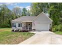 Charming single-story home featuring a welcoming front porch and a well-maintained front yard with an attached garage at 2402 Winfield St, Kannapolis, NC 28083