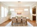 Dining room with hardwood floors, neutral walls, and a modern light fixture at 2415 Christenbury Hall Nw Dr, Concord, NC 28027