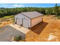 Exterior view of metal building with two garage doors and a concrete slab with two chairs on a gravel area at 2710 Wyatt Grove Church Rd, Richfield, NC 28137