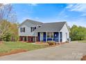 Charming two-story home featuring gray and blue siding, black shutters, and a well-maintained front yard with mature trees at 2948 Christy Leigh Dr, Newton, NC 28658