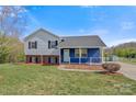 Charming home with light gray and blue siding, black shutters, and a green lawn with mature trees under a blue sky at 2948 Christy Leigh Dr, Newton, NC 28658