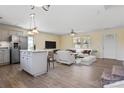 Open-concept living room with a kitchen island, light wood flooring, and modern white furniture at 2948 Christy Leigh Dr, Newton, NC 28658