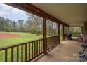 Spacious covered porch with wood beams, offering scenic views of the expansive yard and surrounding nature at 3720 Lanes Creek Rd, Marshville, NC 28103
