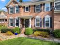 Up-close view of the brick facade, showing the front door, decorative shutters, and landscaping at 4098 Kiser Cove Ln, Terrell, NC 28682