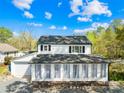 Classic two-story home featuring white siding, black shutters, and a bright sunroom addition at 4375 Creek Ave, Midland, NC 28107
